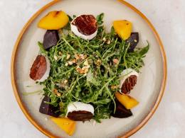 Салат с рукколой, свеклой, персиком, жареным козьим сыром и орешками