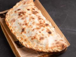 Кальцоне (томатный соус, моцарелла, грибы, шпинат и ветчина)